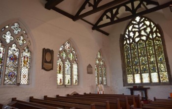 Figure 3: Image of interior of St. Denys church showing plaques and stained-glass windows on the walls by Frank Dwyer (York Press, 2018)